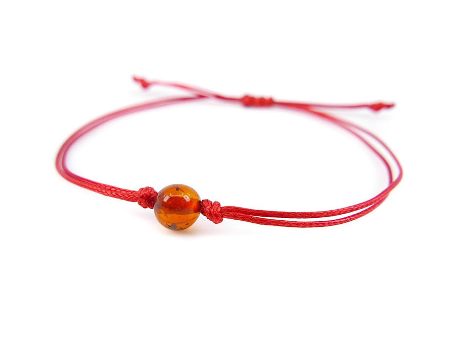 Pulsera de hilo rojo con ámbar báltico pulido en color coñac, diseño elegante y protector