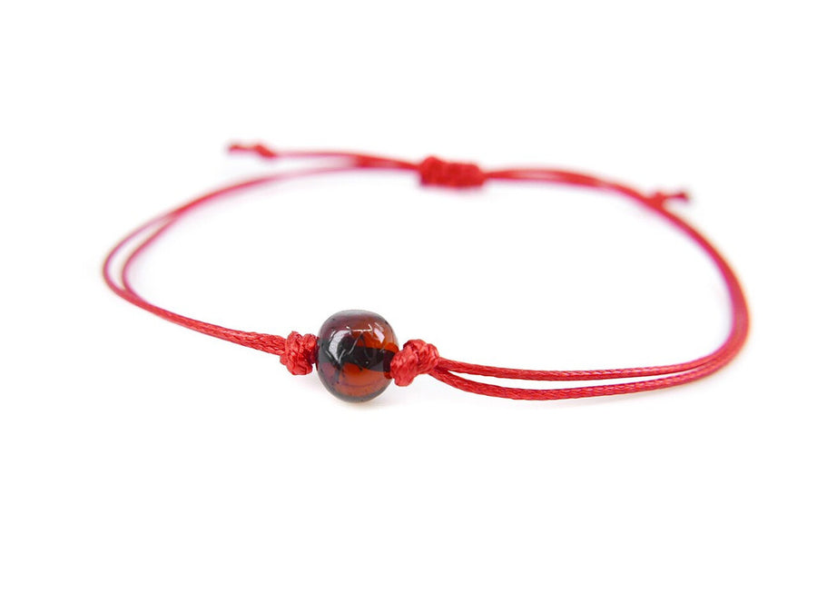 Pulsera de hilo rojo con ámbar báltico pulido en color cereza oscura, diseño elegante y protector