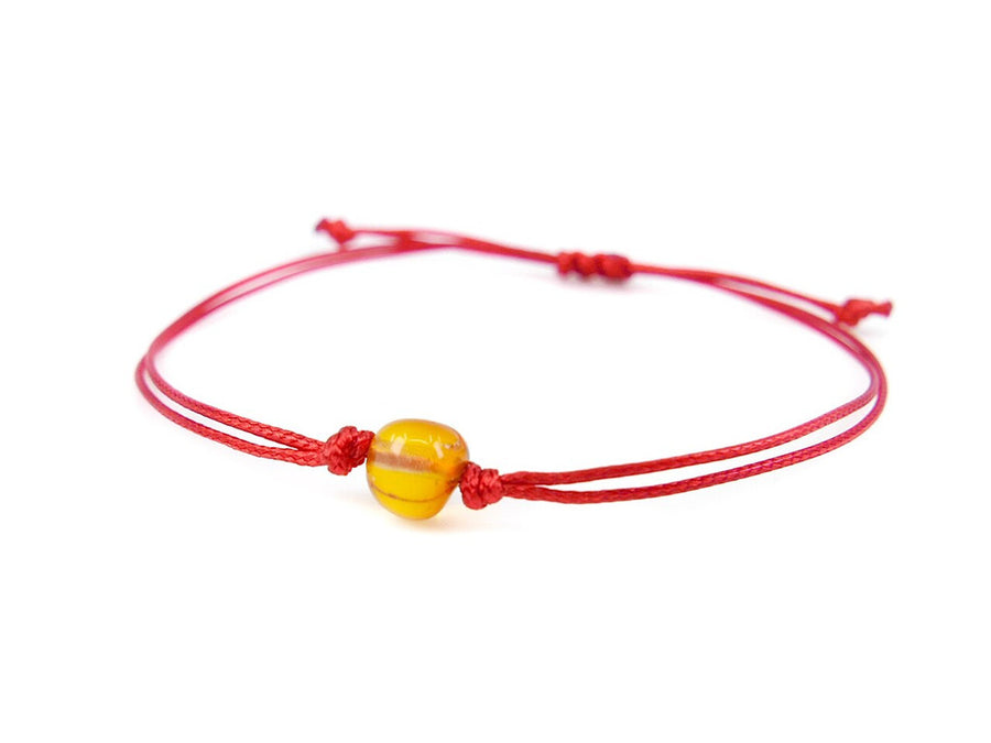 Pulsera de hilo rojo con ámbar báltico pulido en color miel, combinación de estilo y protección