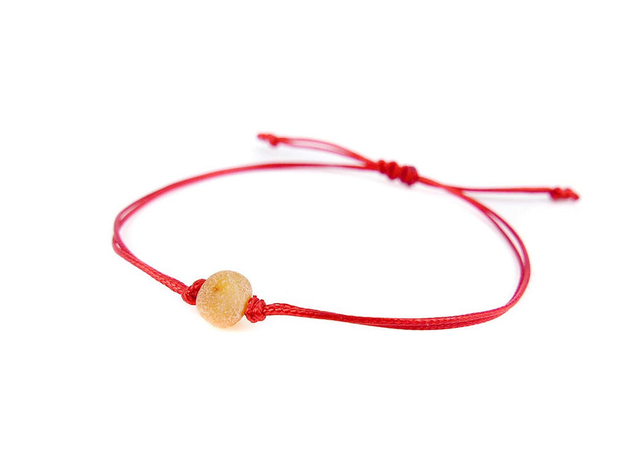Pulsera de hilo rojo con ámbar báltico crudo color miel, diseño artesanal y protector
