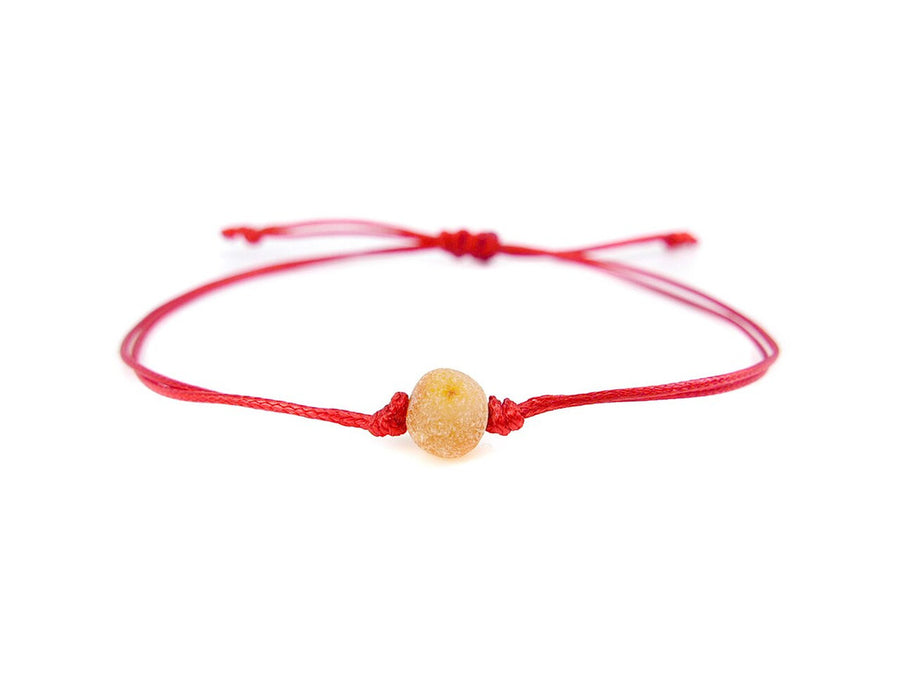 Pulsera protectora de hilo rojo con cuentas de ámbar báltico sin pulir en tono miel