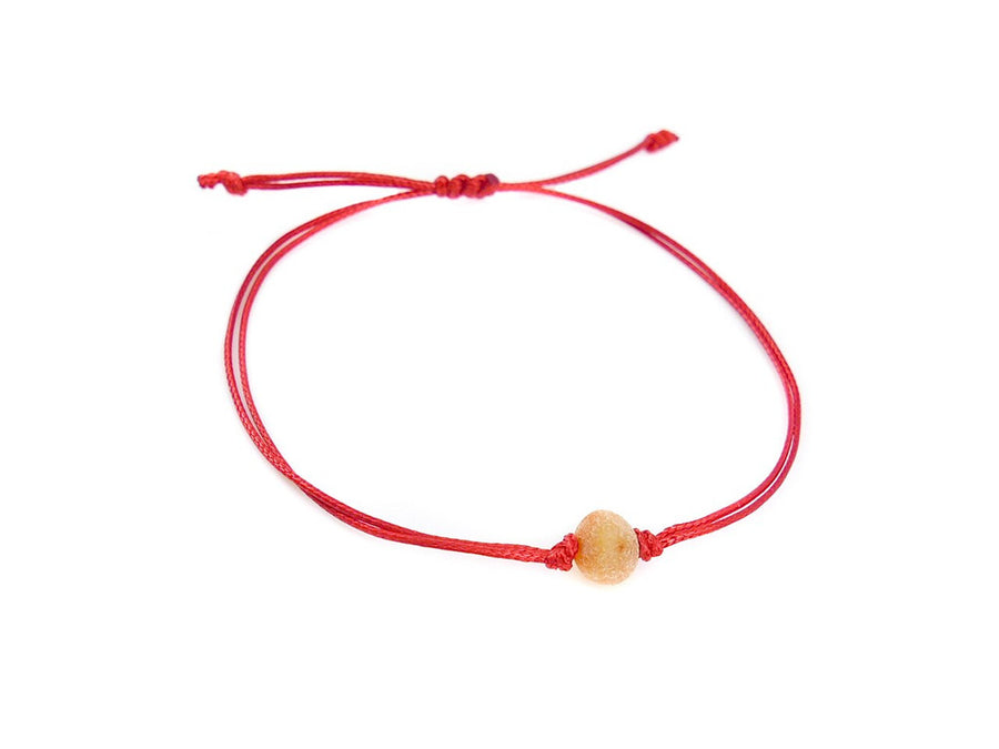 Pulsera artesanal de hilo rojo con ámbar báltico crudo color miel, ideal para bebés y adultos