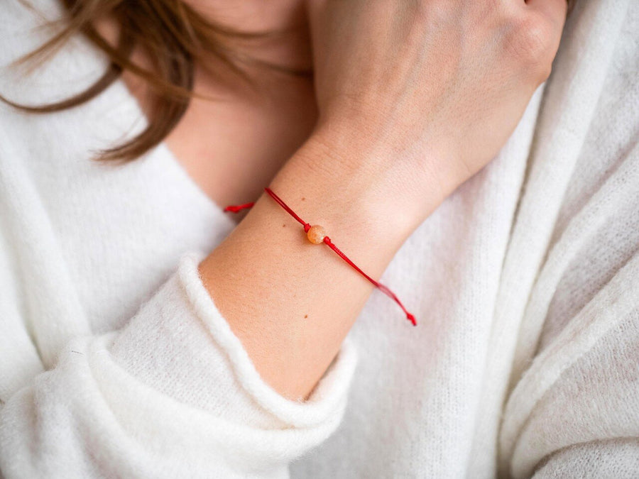 Pulsera ajustable de hilo rojo con ámbar báltico crudo color miel, ideal para equilibrio y energía