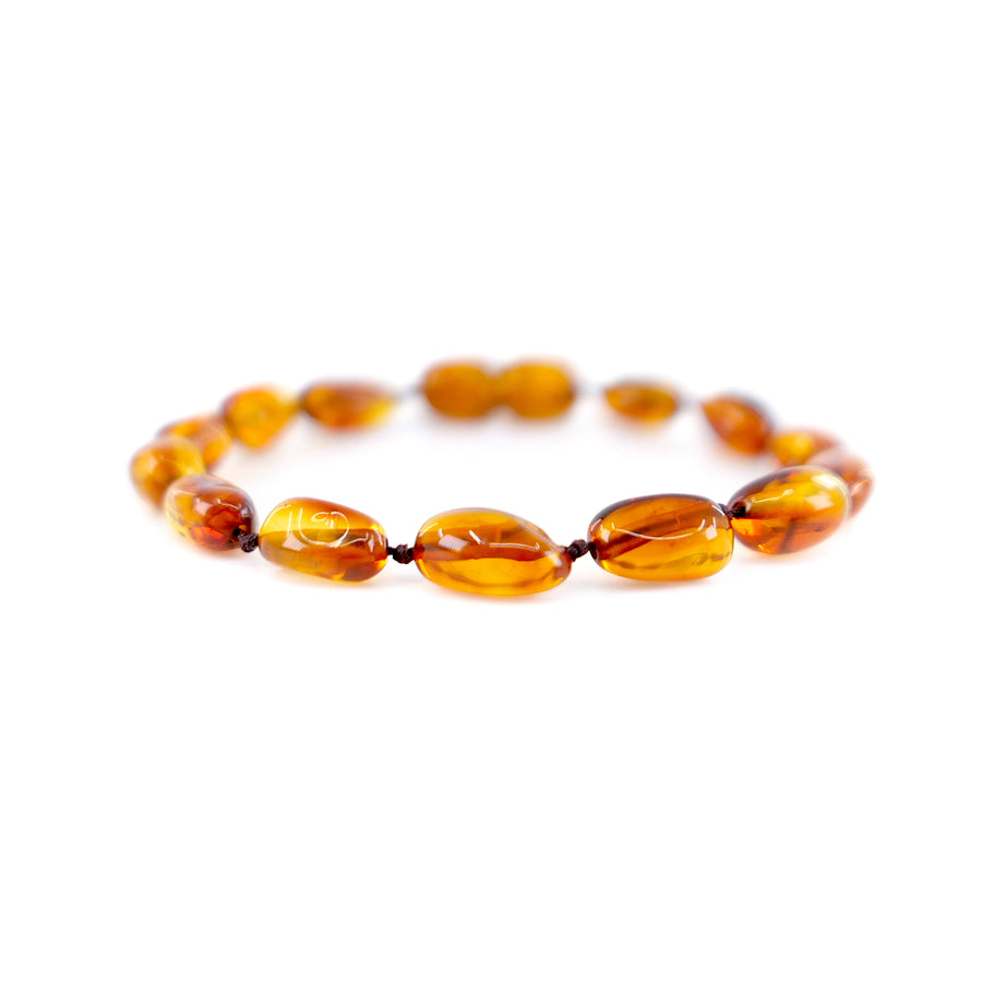 Pulsera artesanal de ámbar báltico cognac con forma de oliva para bebé